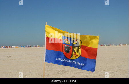 Die friesische Flagge wird gehisst auf dem sandigen Strand Nordstrand auf der nordfriesischen Insel Amrum in Schleswig-Holstein, Deutschland Stockfoto