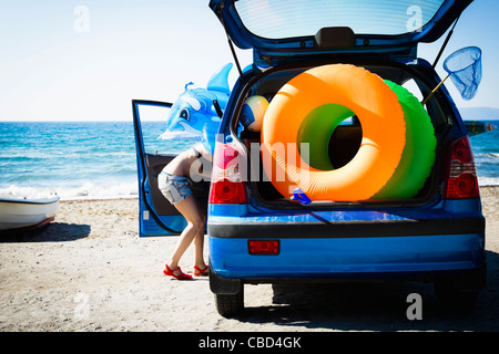 Frau entladen Strandspielzeug aus Auto Stockfoto