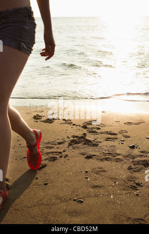 Frau zu Fuß am Strand Stockfoto