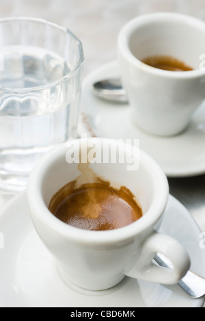 Espresso-Tassen und Glas Wasser Stockfoto