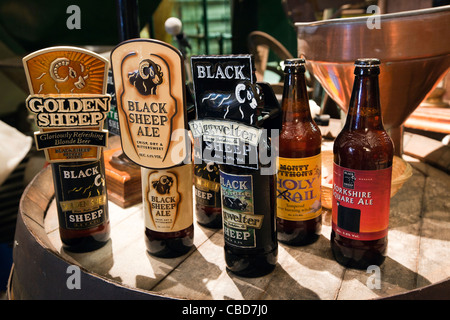 Großbritannien, England, Yorkshire, Masham, Black Sheep Brewery, Flaschenbiere am Ende von altmodisch aus Holz Bierfaß, Stockfoto