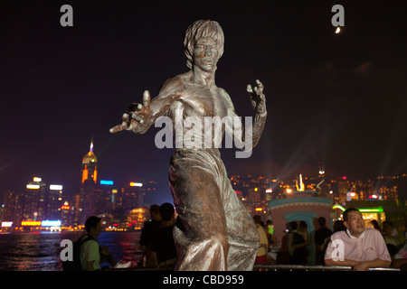 Kung Fu Filmstar Bruce Lee Statue gegen Skyline von Hong Kong Island. Auf der Avenue of Stars-Promenade, Kowloon. China Stockfoto