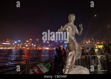 Kung Fu Filmstar Bruce Lee Statue gegen Skyline von Hong Kong Island. Auf der Avenue of Stars-Promenade, Kowloon. China Stockfoto