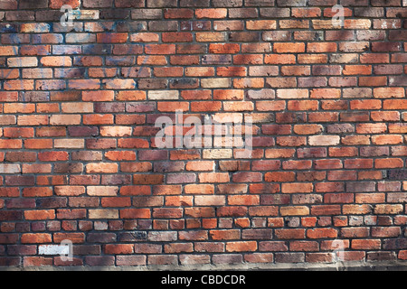 Roten Backsteinmauer mit gesprenkelten Licht Stockfoto