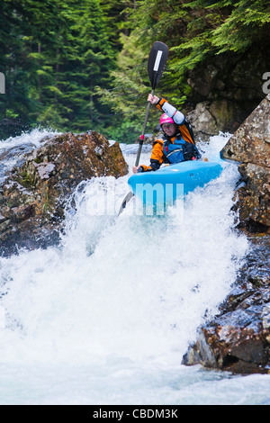 Eine weibliche Kajakfahrer am Snoqualmie River, Washington, USA. Verlieben Sie sich in der Wand. Stockfoto