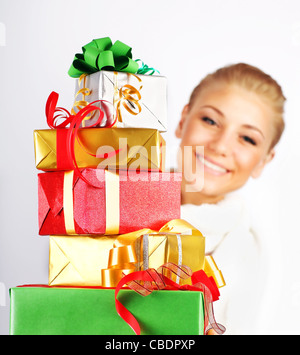 Glückliches Mädchen lächelnd, mit bunten Urlaub Geschenke & Geschenkboxen als Weihnachten & Neujahr Ornament Dekoration isoliert auf weiss Stockfoto