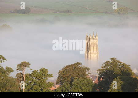 Der Turm der St. John the Baptist Church von Nebel umgeben, von der Spitze des Glastonbury Tor aus gesehen Stockfoto