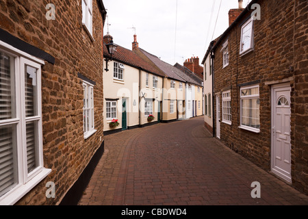 Terrassenförmig angelegten Reihe von schönen alten englischen Cottages in schmalen Seitenstraße, gemalt Deans Street, Oakham, Rutland, England, UK Stockfoto