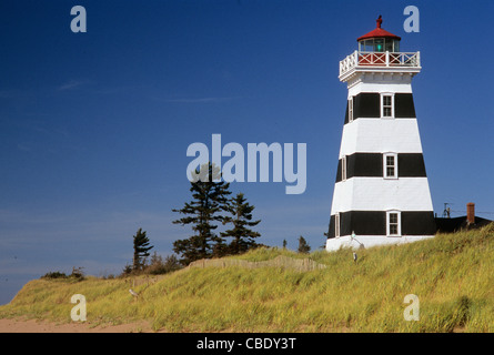 West Point Leuchtturm in Cedar Dunes Provincial Park, Prince Edward Island, Kanada, betrachtet von einem Strand mit grasbewachsenen Dünen Stockfoto