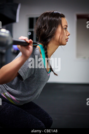 Junge asiatische Frau Rücken Kniebeugen mit Langhantel im Fitness-Studio zu tun. Stockfoto