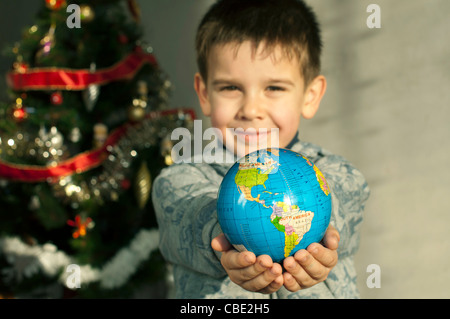 Kind, das als Geschenk die Welt zu Weihnachten zu geben. Stockfoto