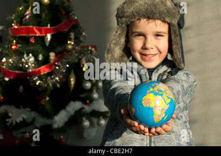 Kind, das als Geschenk die Welt zu Weihnachten zu geben. Stockfoto