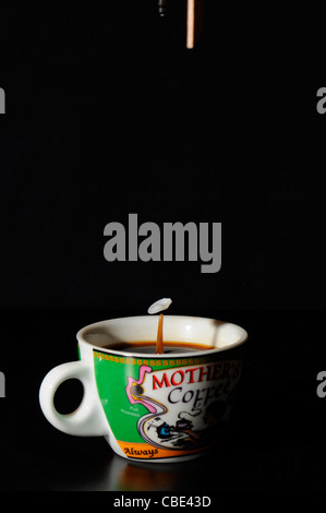 High-Speed-Flash-Foto Milch Tropfen in eine Kaffeetasse. Das Droplet landet in der Flüssigkeit und produziert eine Haube. Stockfoto