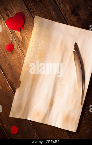 Leere Liebesbrief auf Holz mit Herzen und Feder Stockfoto