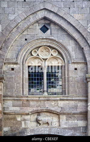 Detail der Fassade mit einem zweibogigen Fenster und der Löwe im Hochrelief, Kirche von San Leonardo in Tuscania, Italien Stockfoto