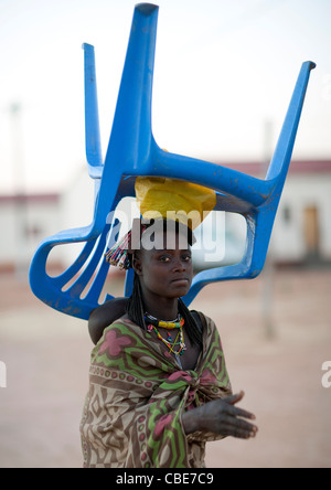 Frau, die einen Stuhl auf dem Kopf, Dorf Oncocua, Angola Stockfoto