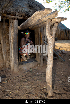 Mucawana Mädchen hocken In den Eingang von ihrer Hütte, Dorf Mahine, Angola Stockfoto