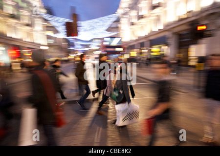 Menschen überqueren der geschäftigen Oxford street Weihnachts-shopping London England Vereinigtes Königreich uk absichtlich Bewegungsunschärfe verrissen Aktion Stockfoto