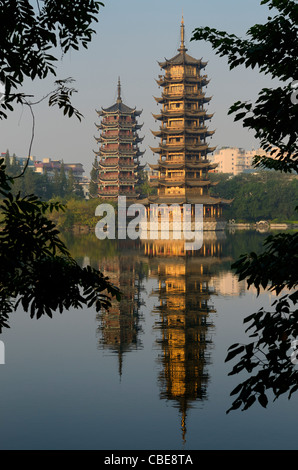 Sonne und Mond Pagoden am Shanhu oder Fir Lake in den frühen Morgenstunden umrahmt von Bäumen in Guilin Peoples Republic Of China Stockfoto