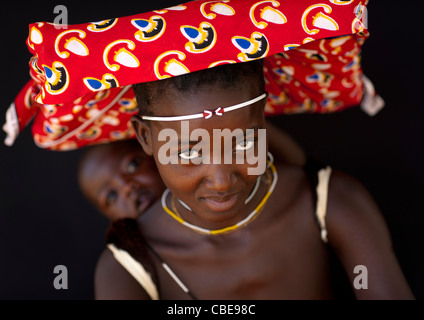 Mucubal Frau mit Ompota, die mit ihrem Baby auf dem Rücken, Virie Bereich, Angola Stockfoto