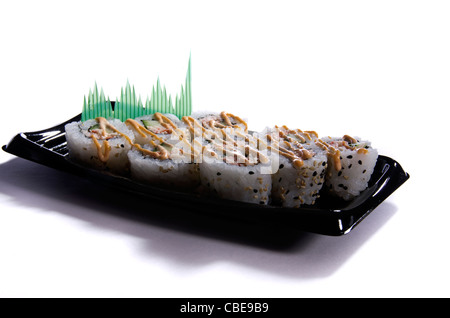 Nahaufnahme von würzigen California Sushi-Rollen auf einer schwarzen Platte. Stockfoto