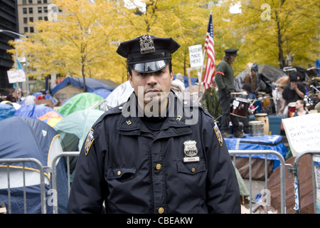 Ernsthafte Suche NYPD Officer bei der Besetzt die Wall Street Feldlager in Downtown Manhattan an Zuccotti Park, New York City. Stockfoto
