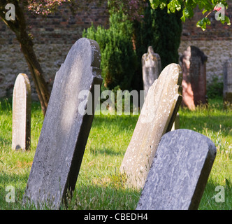Alte Grabsteine in einem sonnigen Land Friedhof beugte sich über Stockfoto
