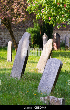 Alte Grabsteine in einem Land Friedhof beugte sich über Stockfoto