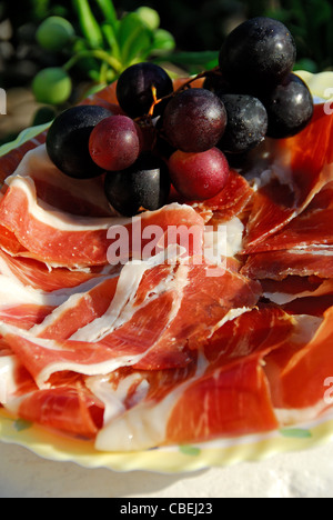 Kroatien. Ein Teller mit dünn geschnittenen Dalmatiner geräucherter Schinken (Prsut) mit Trauben. 2010. Stockfoto