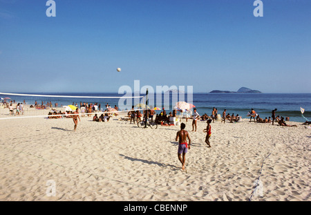 Rio De Janeiro, Brasilien. Junge Menschen spielen Sie Volleyball am Strand der Copacabana mit Sunhades hinter. Stockfoto