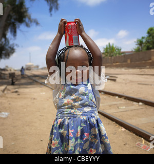 Junge Mädchen Holding A Can auf dem Kopf, Stadt Namibe, Angola Stockfoto