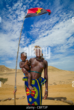 Mucuroca Frau mit ihr Baby unter der angolanischen Flagge Twe Villge, Sao Joao Sul Bereich, Angola Stockfoto