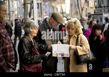 Besucher vor der St. Patricks Kathedrale auf der 5th Avenue finden Sie eine touristische Karte für ihre nächste Station in New York. Stockfoto