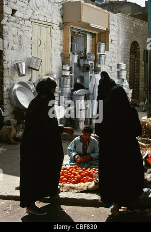 Weibliche Käufer in Burkas und Tomaten Lieferanten, Basar, Assuan, Ägypten Stockfoto