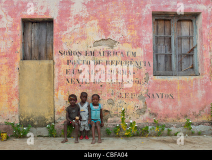 Kinder vor eine alte kommunistische Propaganda-Nachricht geschrieben am Fassade, Bilaiambundo, Angola Stockfoto