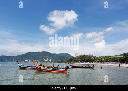 Traditionelle Thai lange tailed Boote in die Bucht von Patong Beach in Patong, Phuket, Thailand Stockfoto