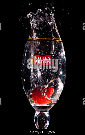 Eine Erdbeere sank auf ein mit Wasser gefülltes Stella Artois Glas Stockfoto