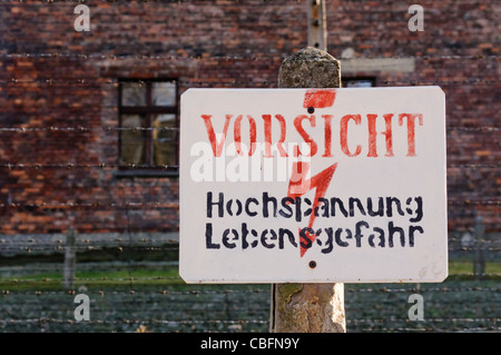 Schild am elektrischen Stacheldrahtzaun in Auschwitz "hochgeliebten: Hochspannung Lebensgefahr" (Gefahr: Hochspannung) Stockfoto