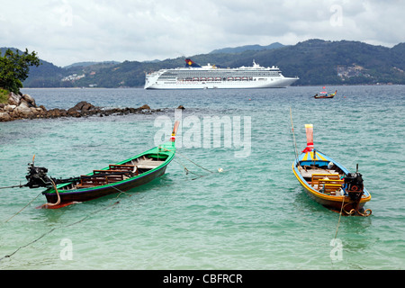 Sterne Jungfrau von Star Cruises Kreuzfahrt-Schiff und traditionellen Thai lange Tailed Boote in Patong, Phuket, Thailand Stockfoto