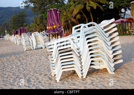 Urlaub-Strand-Szene mit Sonnenliegen und Sonnenschirme am Sandstrand von Patong Beach, Patong, Phuket, Thailand Stockfoto