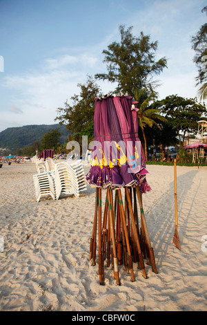 Urlaub-Strand-Szene mit Sonnenliegen und Sonnenschirme am Sandstrand von Patong Beach, Patong, Phuket, Thailand Stockfoto