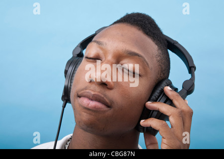 Ein junger Mann Musikhören mit Kopfhörer, schloss die Augen Stockfoto