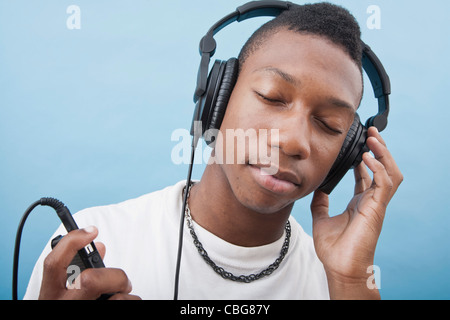 Ein junger Mann Musikhören mit Kopfhörer, schloss die Augen Stockfoto