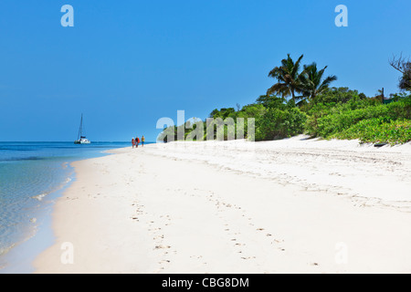 Familie im Urlaub auf einer tropischen Insel mit Luxus Yacht und weiße Strände mit blauem Himmel unberührten weißen Strand entlang spazieren. Stockfoto