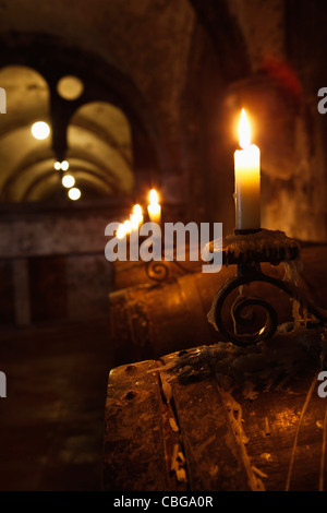 Fässer Wein im Keller mit Kerzenlicht beleuchtet Stockfoto