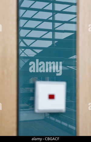 Treppe spiegelt sich auf Glaswand mit unscharfen Lichtschalter im Vordergrund Stockfoto