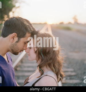 Ein junges Paar berühren Stirn nahe Bahngleis Stockfoto