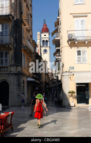 EINE GUT GEKLEIDETE FRAU ZU FUß DURCH DIE ALTSTADT VON KORFU. GRIECHISCHEN IONISCHEN INSEL KORFU. Stockfoto