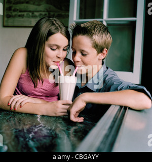 Ein junger Teenager Paar teilen einen Milchshake in einem diner Stockfoto
