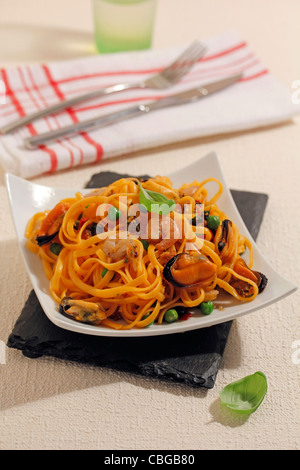 Orangefarbene Spaghetti mit Muscheln und Garnelen. Rezept zur Verfügung. Stockfoto